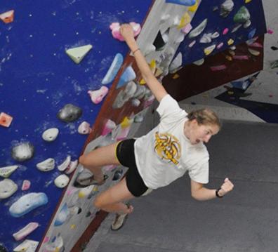 Close up image of student on bouldering wall.
